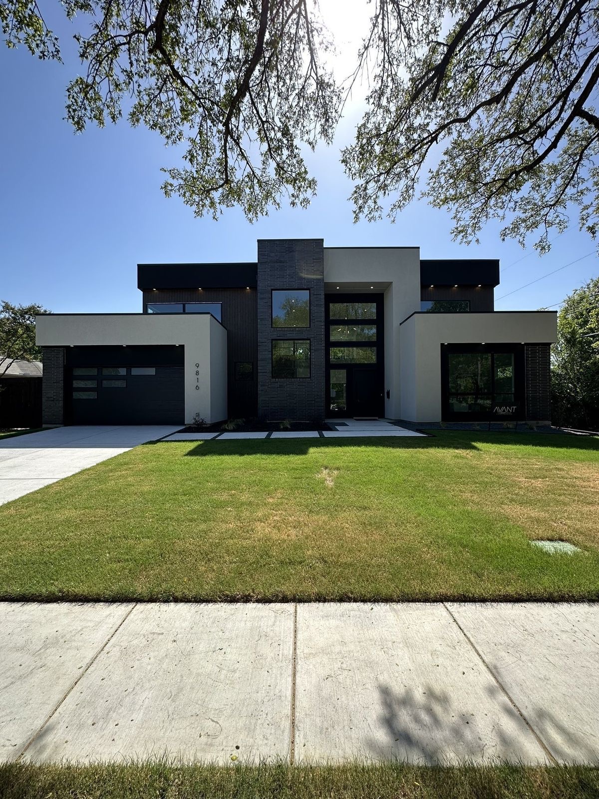 Black-and-white contemporary residence with a broad lawn